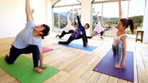 A yoga class in a room with large windows, wooden floors, and a view of the outdoors. - Holiday Inn Resort MIYAZAKI by IHG (Miyazaki City)