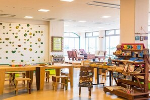 A children's play area with climbing walls, tables, chairs, and a bookshelf with toys. - Holiday Inn Resort MIYAZAKI by IHG (Miyazaki City)