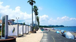 A seaside promenade with palm trees, a clear sky, and a beach in the background. - Holiday Inn Resort MIYAZAKI by IHG (Miyazaki City)