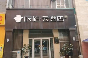Entrada de un hotel con un cartel que dice '派柏·云酒店'.