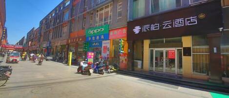 A street with shops and a building with a sign that says 'oppo'.
