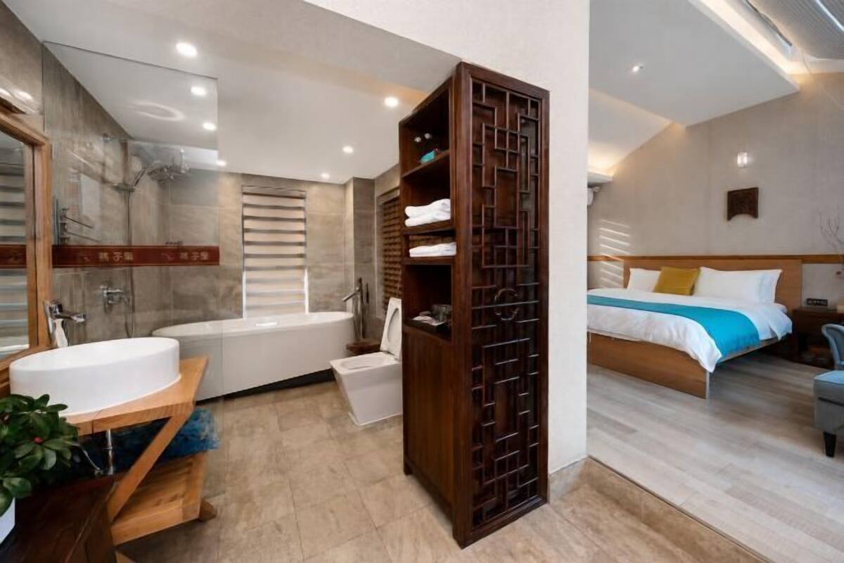 Een moderne badkamer met een bad, wastafel en douche.