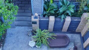 A rooftop garden with a seating area, plants, and a small table.
