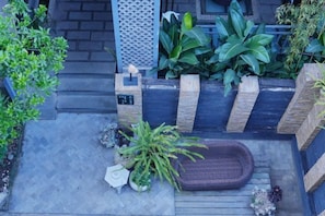 A rooftop garden with a seating area, plants, and a small table.