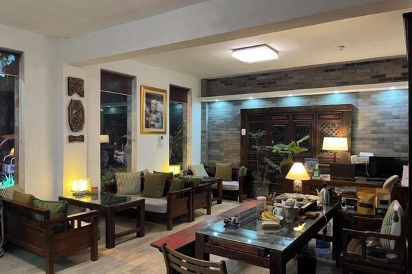 A living room with a dining area, wooden furniture, a television, and a fireplace.