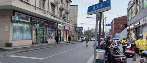 A street with buildings, a crosswalk, and parked motorcycles.