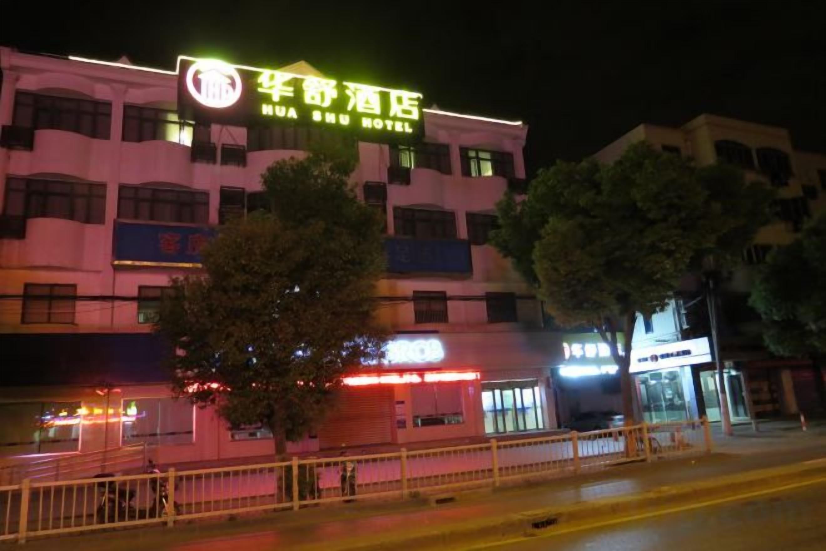 Un hotel con letreros llamativos, varios pisos y una entrada visible.