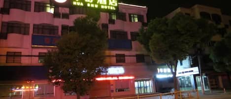 A hotel with a prominent signage, multiple floors, and a visible entrance.
