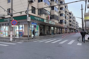 A street with an 'Oppo' store, a pedestrian crossing, and a person walking.