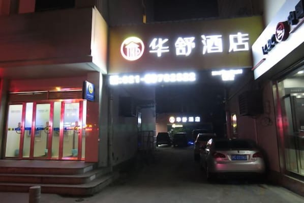 A hotel entrance with a neon sign, a visible reception desk, and a parked car. - Thank You Inn (Shanghai Xianghuaqiao) (Shanghai)