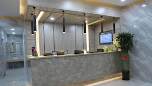 A modern reception area with a marble counter, pendant lighting, and a digital screen. - Thank You Inn (Shanghai Xianghuaqiao) (Shanghai)