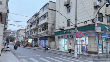 Rua com edifícios, faixa de pedestres e placa de proibido estacionar.