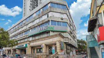 Un edificio de varios pisos con un letrero verde que indica un comercio.