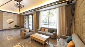 A modern living room with a sofa set, a coffee table, and a chandelier. - Suzhou Impression Hotel (Pingxiang)