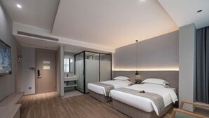 A modern hotel room with two beds, a sitting area, and a large mirror. - Suzhou Impression Hotel (Pingxiang)