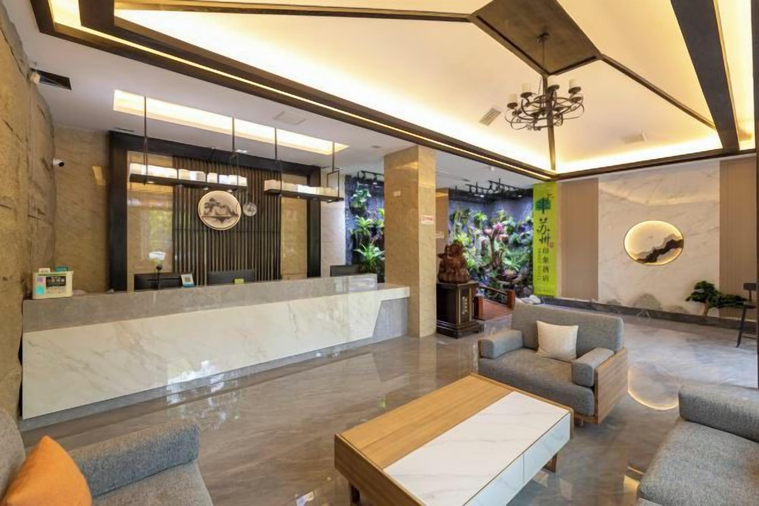 A modern lobby with a reception desk, seating area, and decorative wall art.
