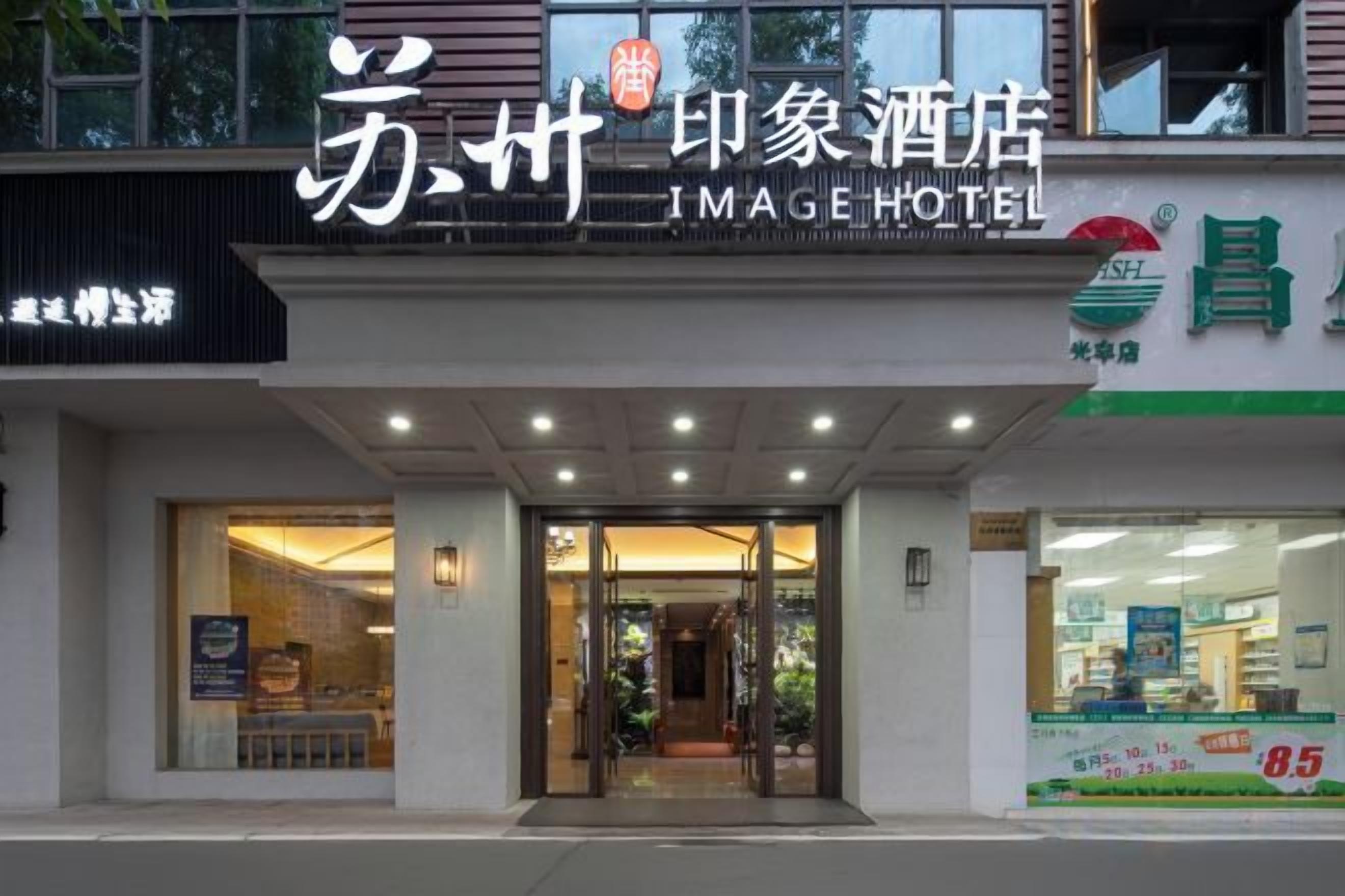 Entrada de un hotel con un cartel que dice 'Image Hotel' y un escaparate visible con una etiqueta de precio de 85.