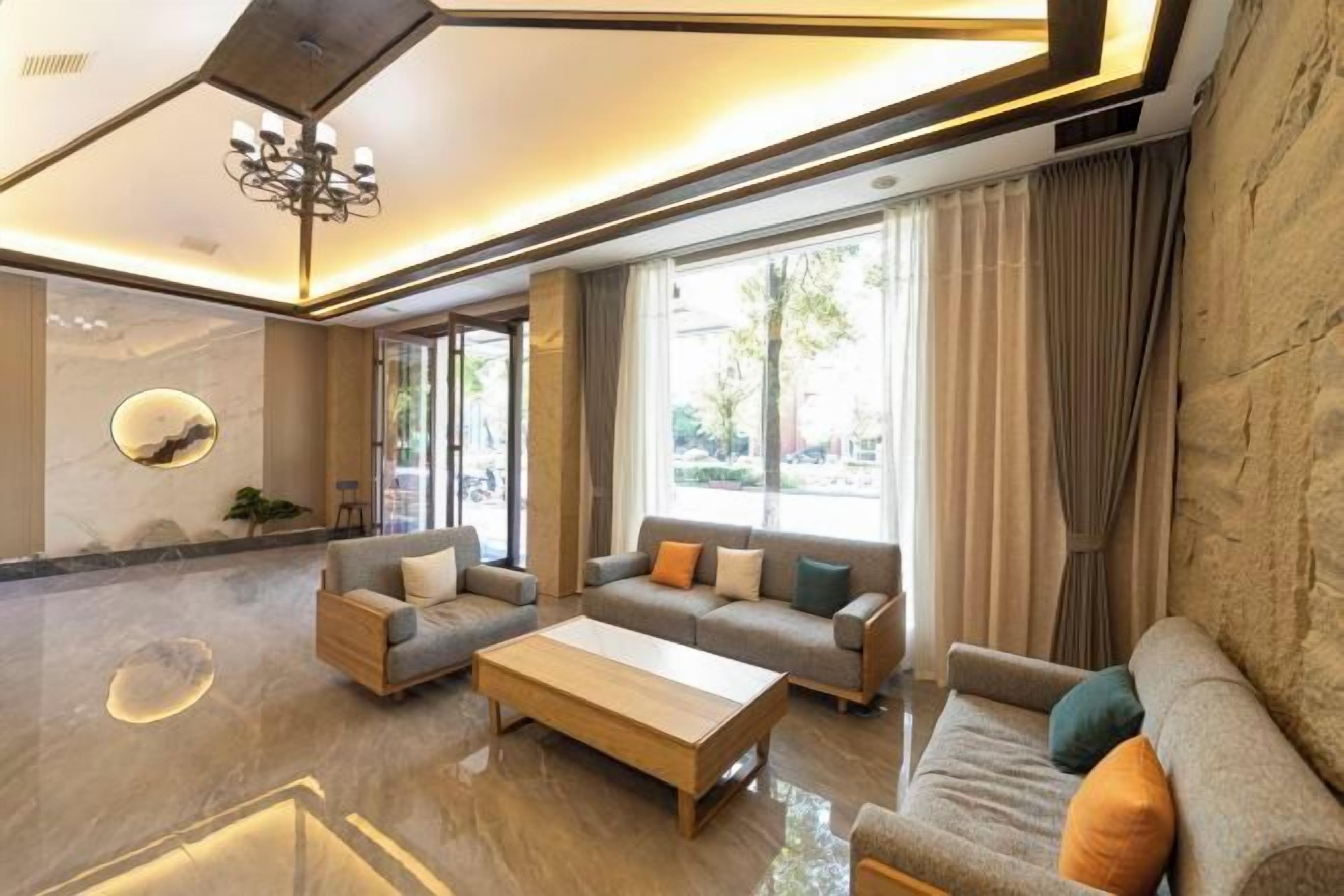 A modern living room with a sofa set, a coffee table, and a chandelier.
