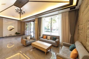 A modern living room with a sofa set, a coffee table, and a chandelier. - Suzhou Impression Hotel (Pingxiang)