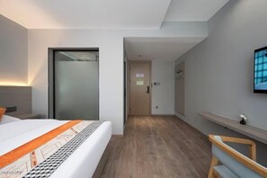 A modern hotel room with a bed, a desk, a chair, and a TV on the wall. - Suzhou Impression Hotel (Pingxiang)