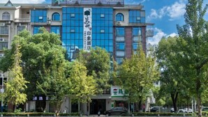 A hotel with a modern facade, multiple floors, and a prominent sign indicating it is a hotel. - Suzhou Impression Hotel (Pingxiang)
