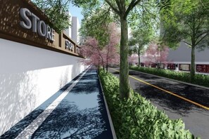 Una vorera amb un rètol de botiga, arbres i un carrer.