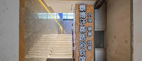 A staircase leading to a room with a sign indicating a traditional Chinese bathhouse.