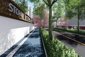 A sidewalk with a store sign, trees, and a road. - Bu can't thirst Wisdom Hotel (Shanghai)