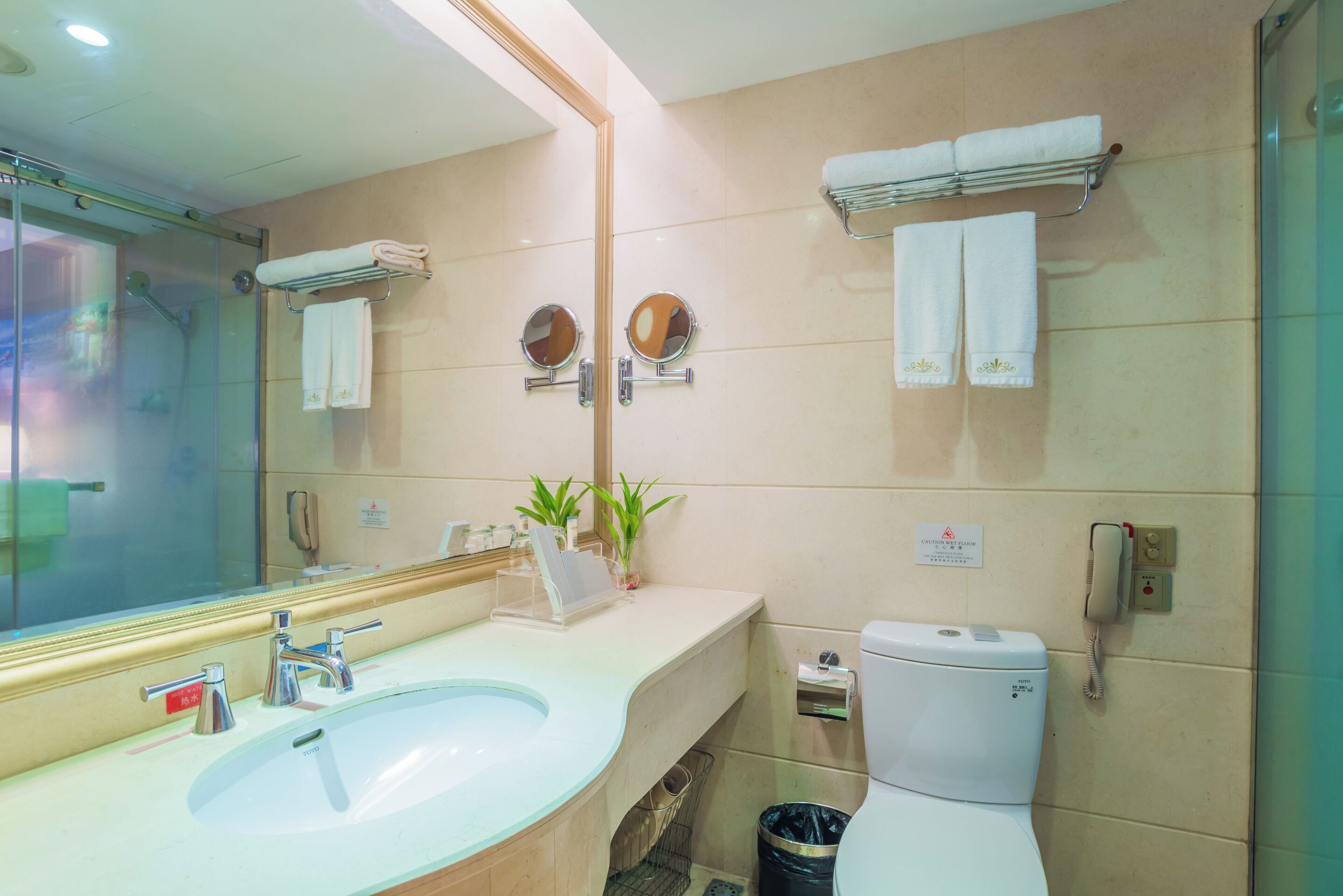 Een badkamer met een wastafel, spiegel, toilet en handdoekhouder.
