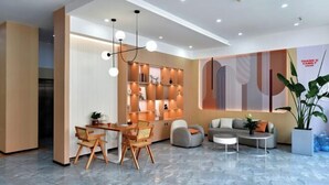 Un moderno vestíbulo con zona de comedor, asientos y una pared decorativa.