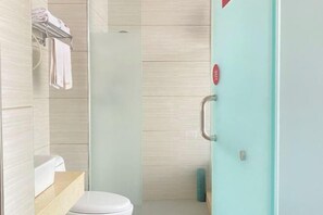 Une salle de bain moderne équipée de toilettes, d’une douche à parois de verre et d’un porte-serviettes.