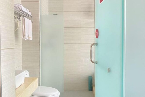 Ein modernes Badezimmer mit Toilette, Duschkabine aus Glas und Handtuchhalter.
