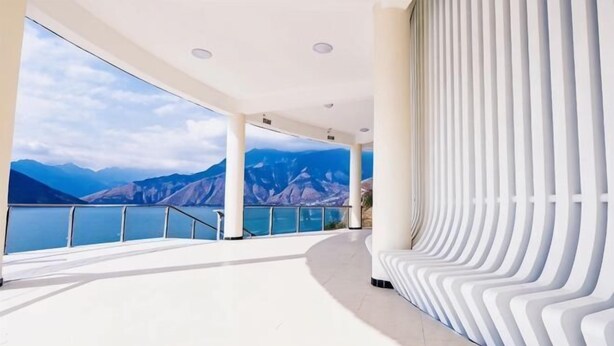 Un interior amplio con un gran ventanal con vistas a un paisaje montañoso.