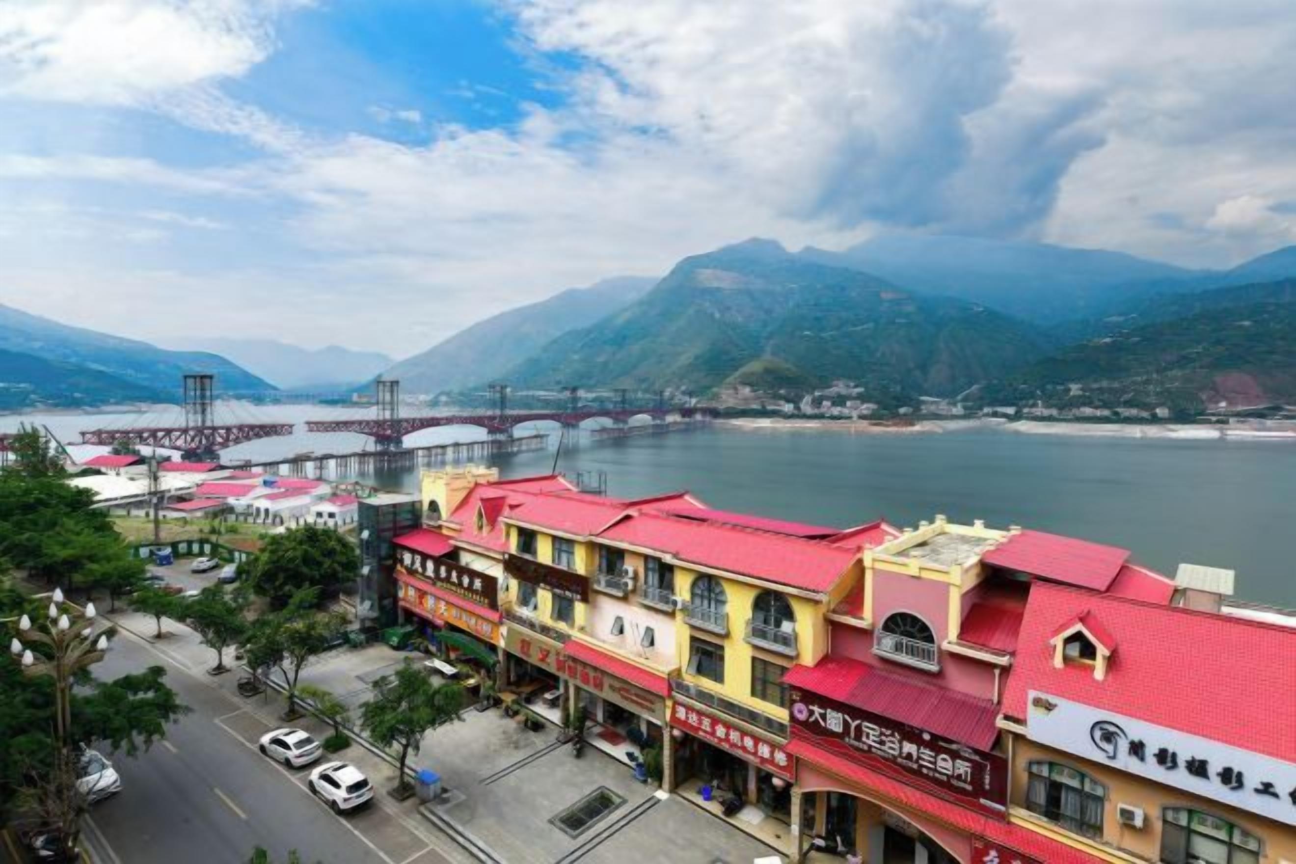 A coastal town with a prominent bridge, colorful buildings, and a view of the sea.