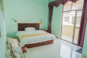 Um quarto com uma cama, mesa de cabeceira, cadeira e janela com cortinas.