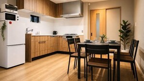 Una cucina moderna con mobili in legno, un'area pranzo con tavolo e sedie, e un forno integrato.