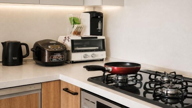A kitchen with a stove, a coffee maker, a toaster, and a kettle. - Joy Home Tankachaya (Osaka)