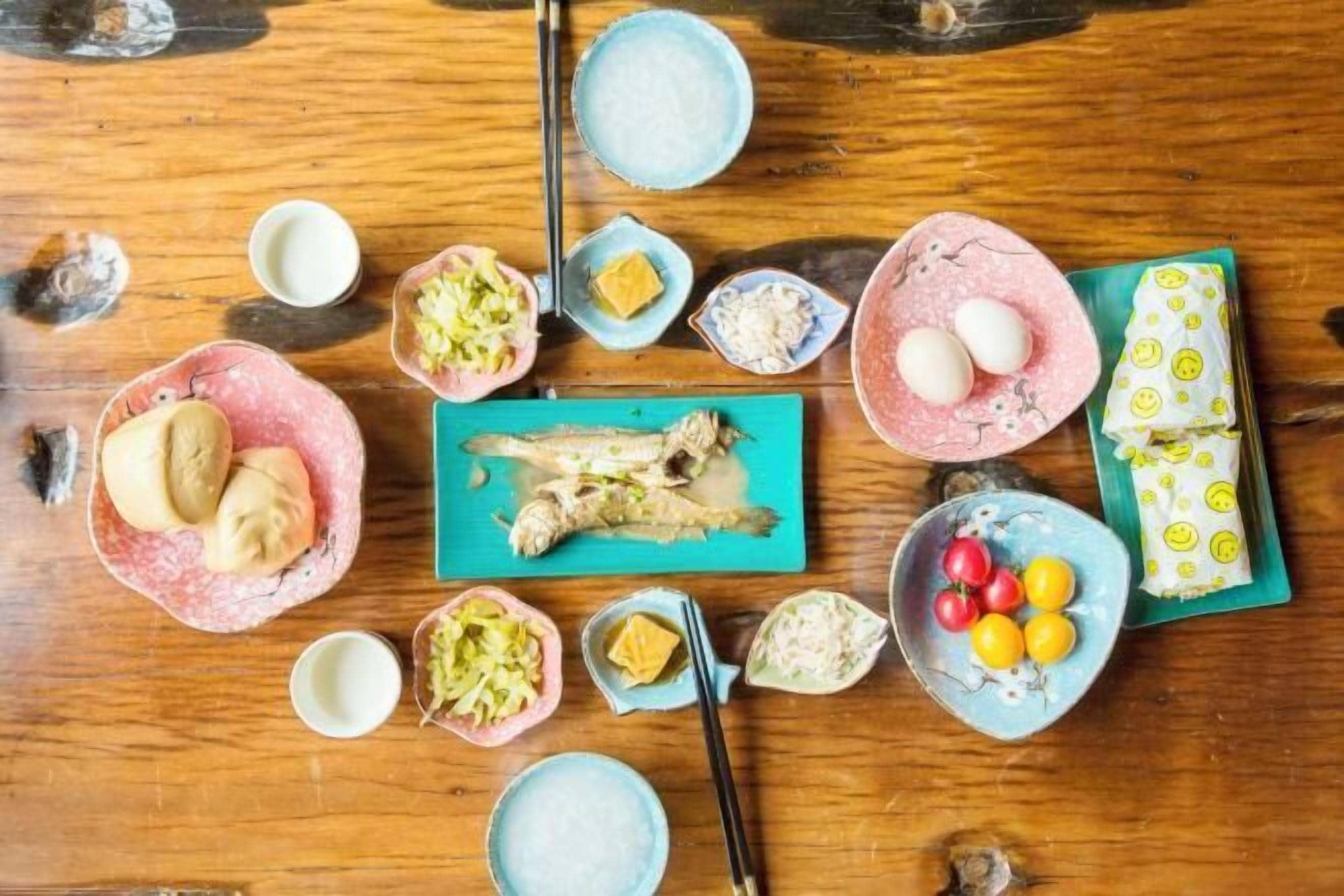 A wooden table with various food items and condiments.