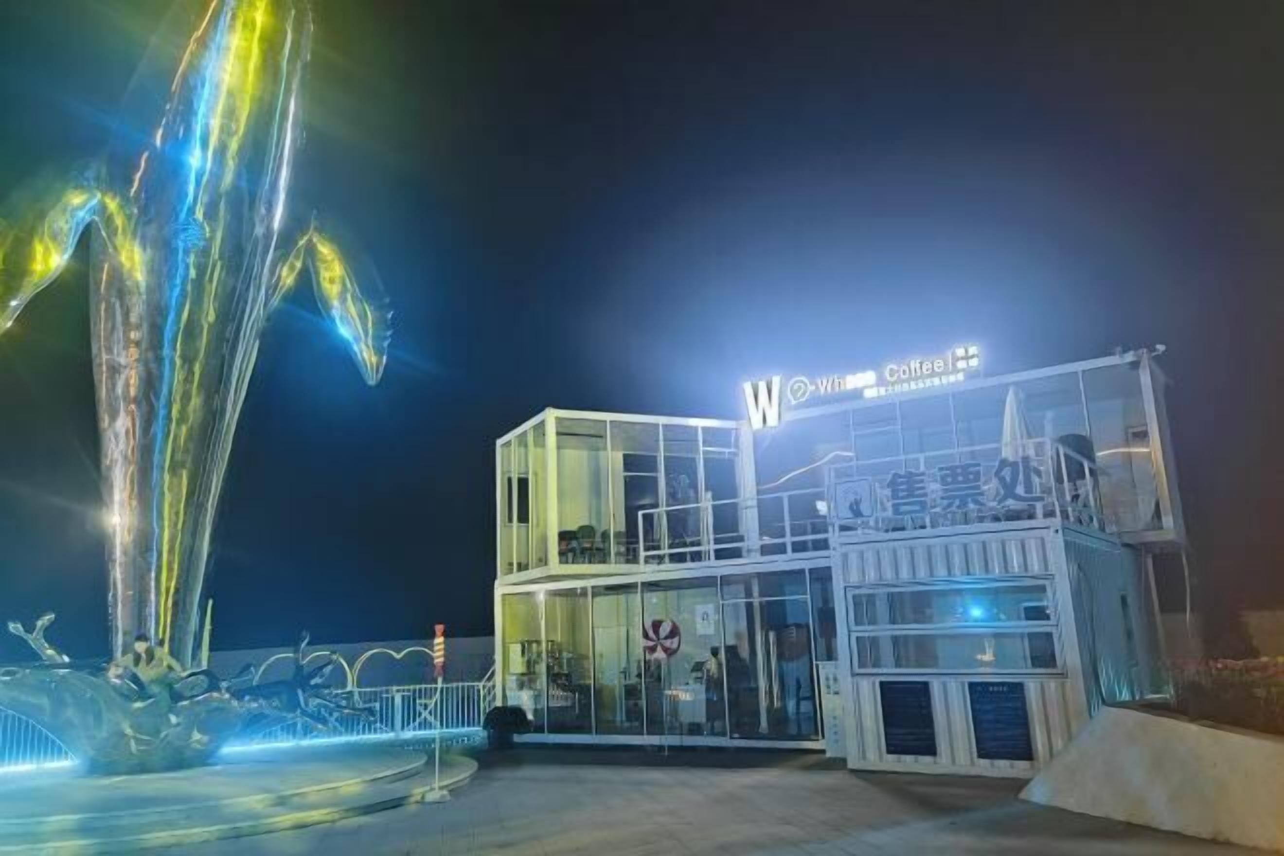 A modern building with a glass facade and a sign that reads "W Coffee."