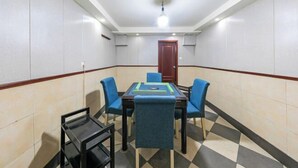 A conference room with a rectangular table, four blue chairs, and a black side table. - Ningyuan Homestay (Zhoushan)
