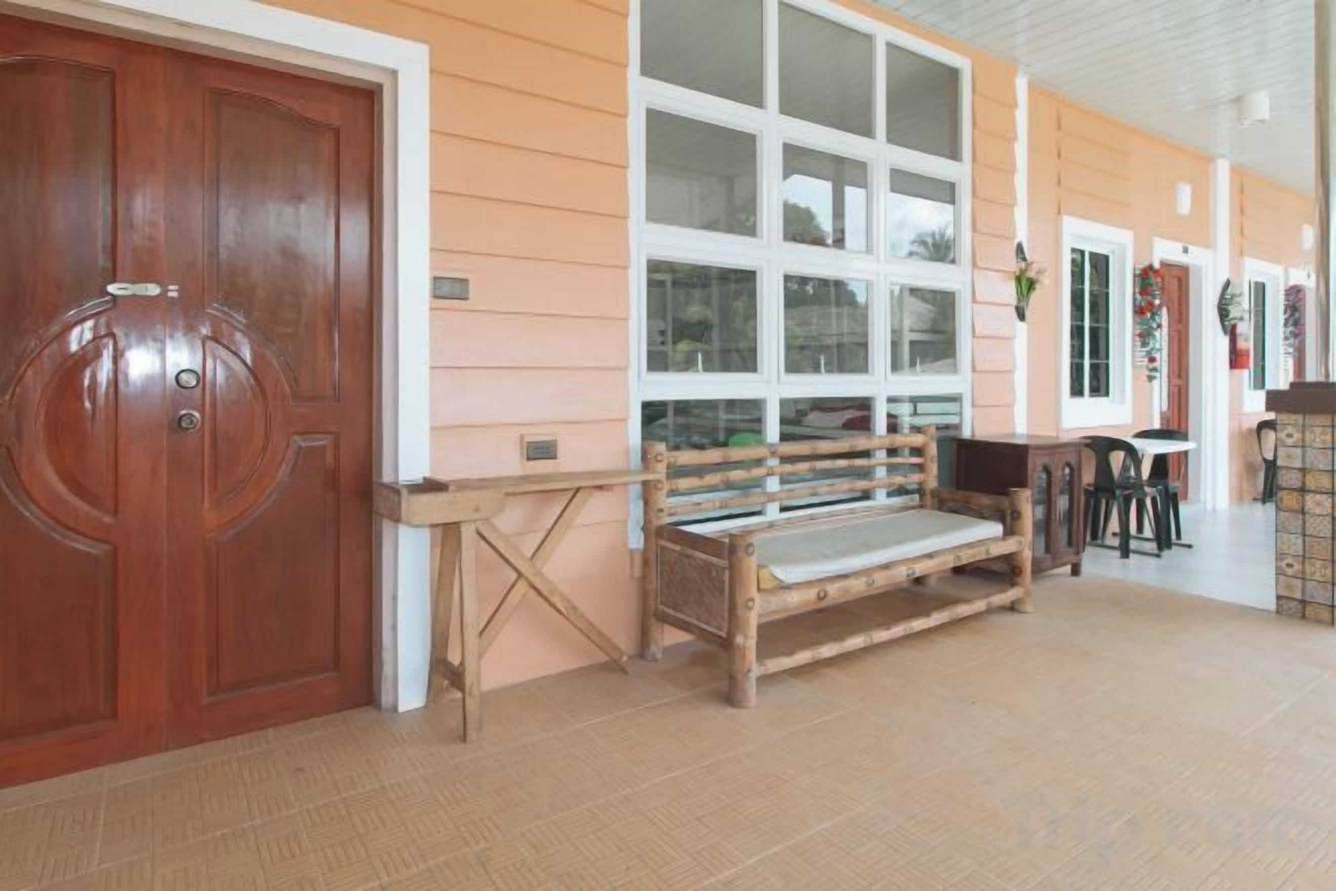 A wooden bench, a door, and a window in a room with a tiled floor.