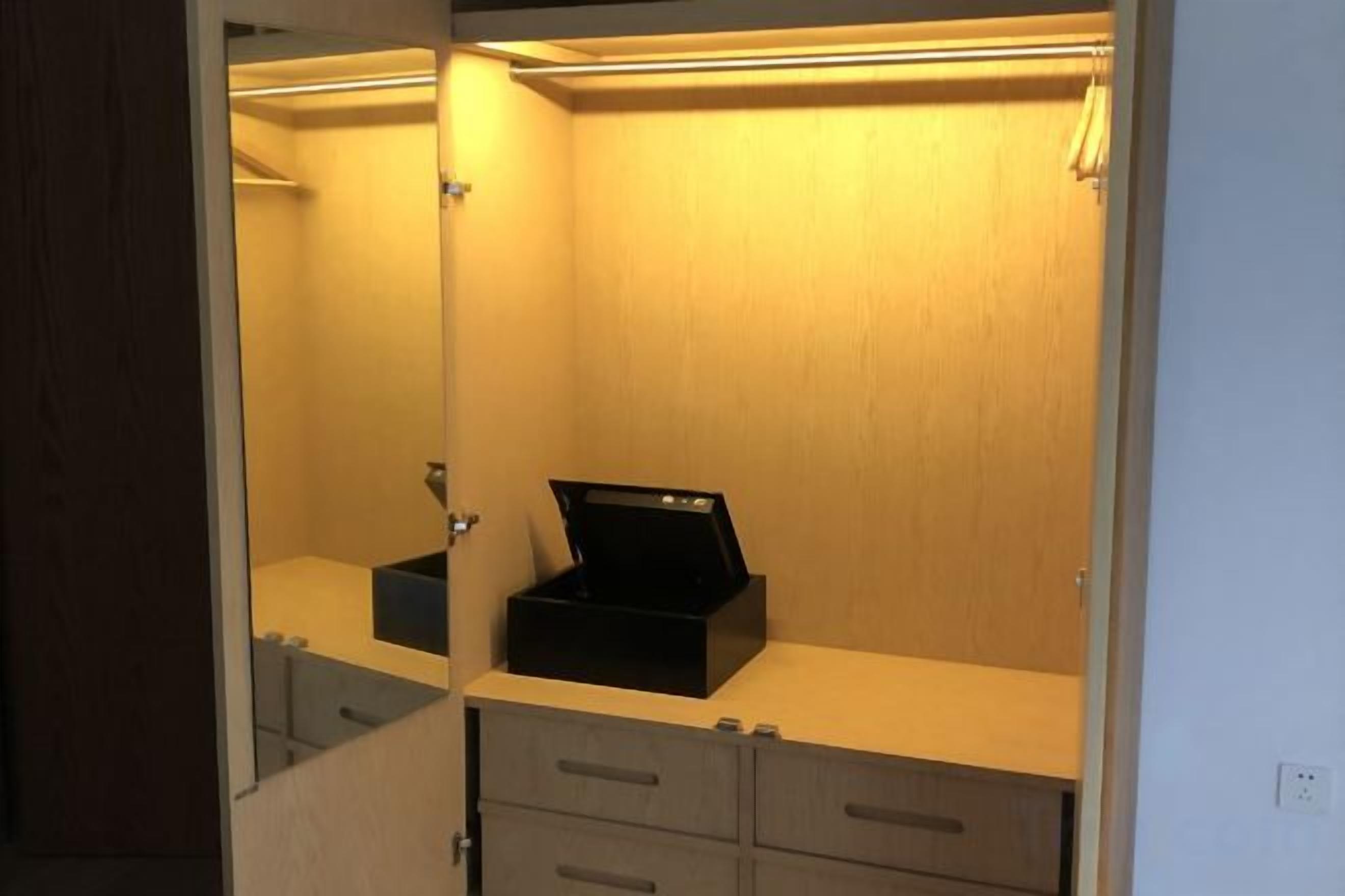 Ein Kleiderschrank mit Spiegel, Ablagefläche und einer Kiste.