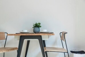 A dining table with two chairs, a potted plant, and a small table lamp. - baseLITE-WESTBUND Serviced Apartment (Shanghai)
