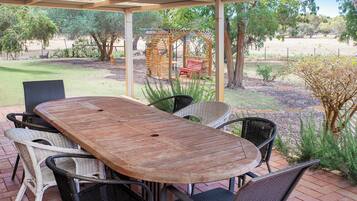 Relax on the shaded patio surrounded by lush gardens.