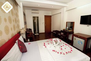 A hotel room with a bed, a desk, a TV, and a minibar. - Hoa Hong Xa Dan 2 Hotel (Hanoi)