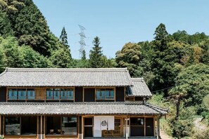 A traditional Japanese building with a tiled roof, large windows, and a sign with Japanese characters. - Tsuzuya Village, a guesthouse with a full-fledged private sauna (Minokamo)