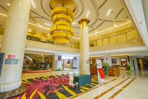 A spacious lobby with a central staircase, a reception desk, and a patterned carpet. - Haocheng International Hotel (Sanyuan)