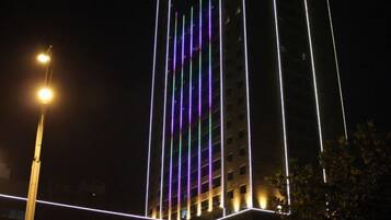 Um edifício alto com fileiras verticais de luzes.