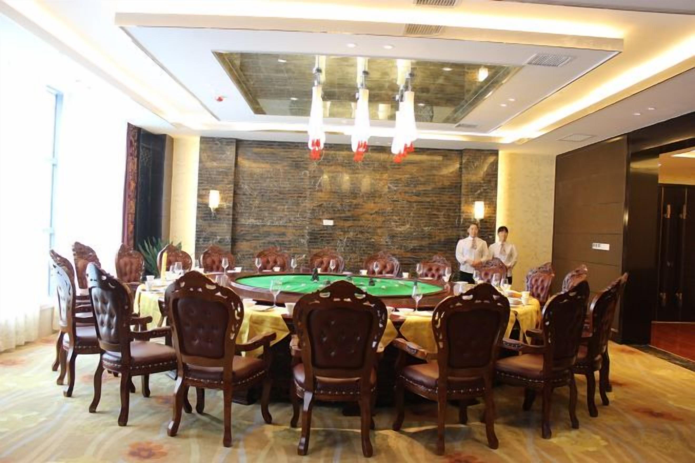 Une salle de conférence avec une longue table, des chaises et une table de jeu recouverte de feutre vert.