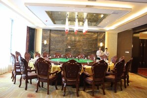 A conference room with a long table, chairs, and a green felt table for a game. - Haocheng International Hotel (Sanyuan)
